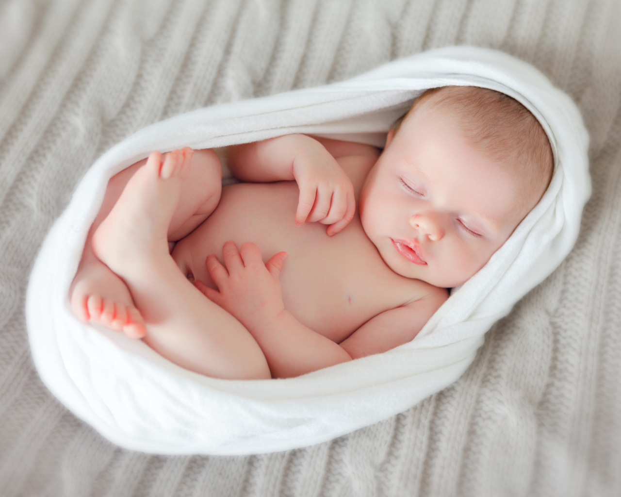 Милый спящий младенец в белом покрывале