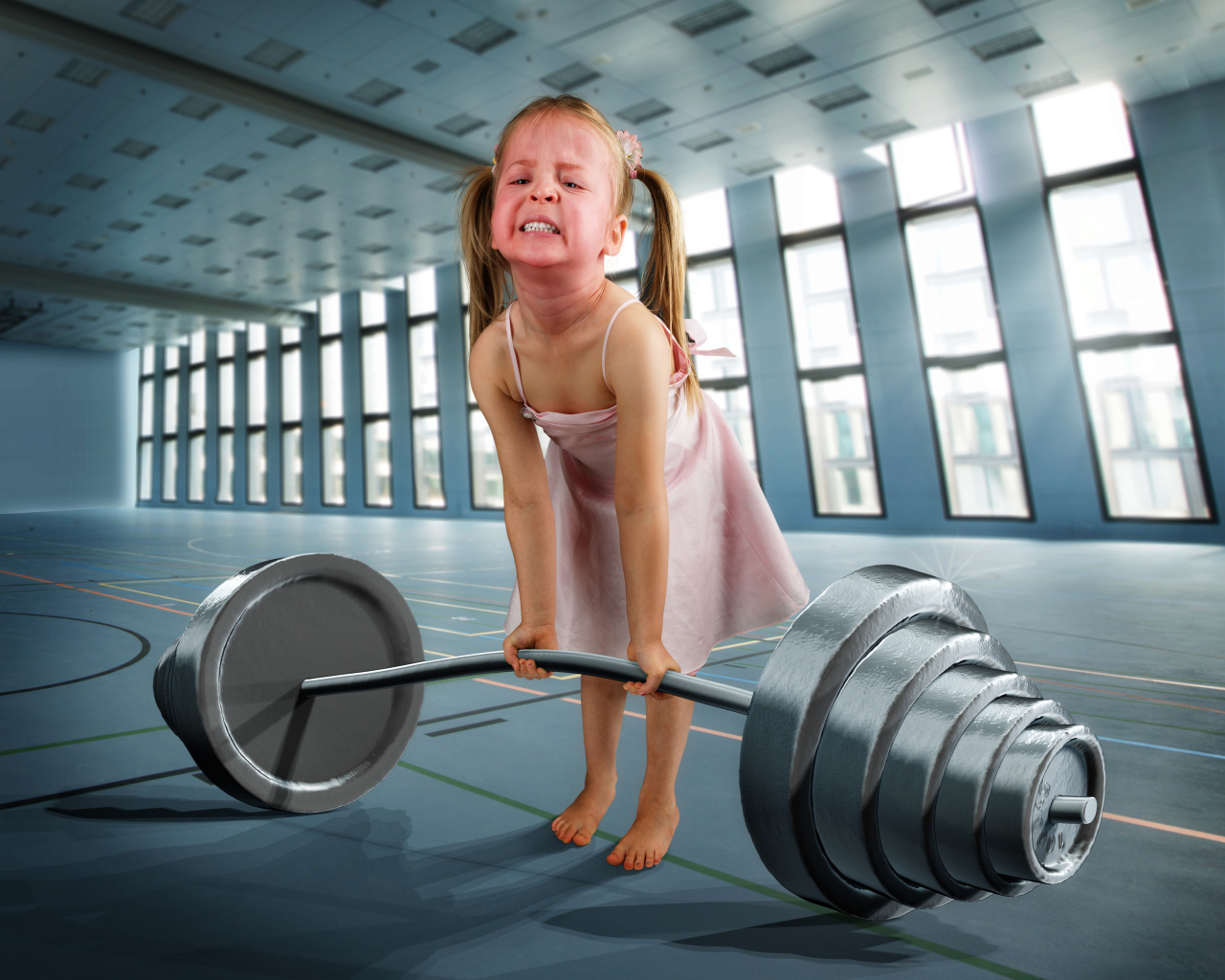 Смешная девочка пытается поднять тяжелую штангу