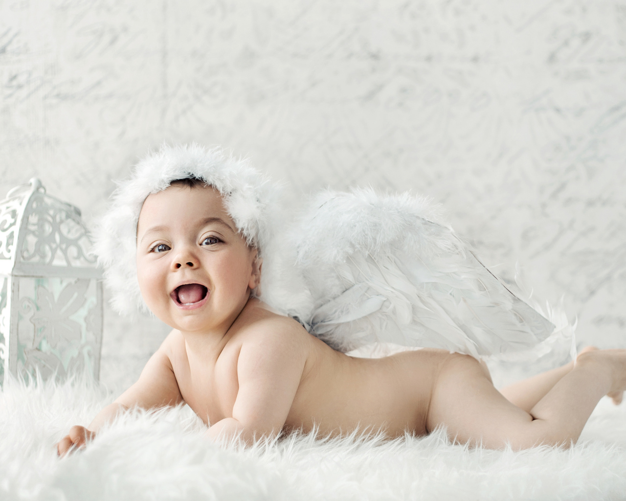 Забавный улыбающийся ребенок с крыльями ангела