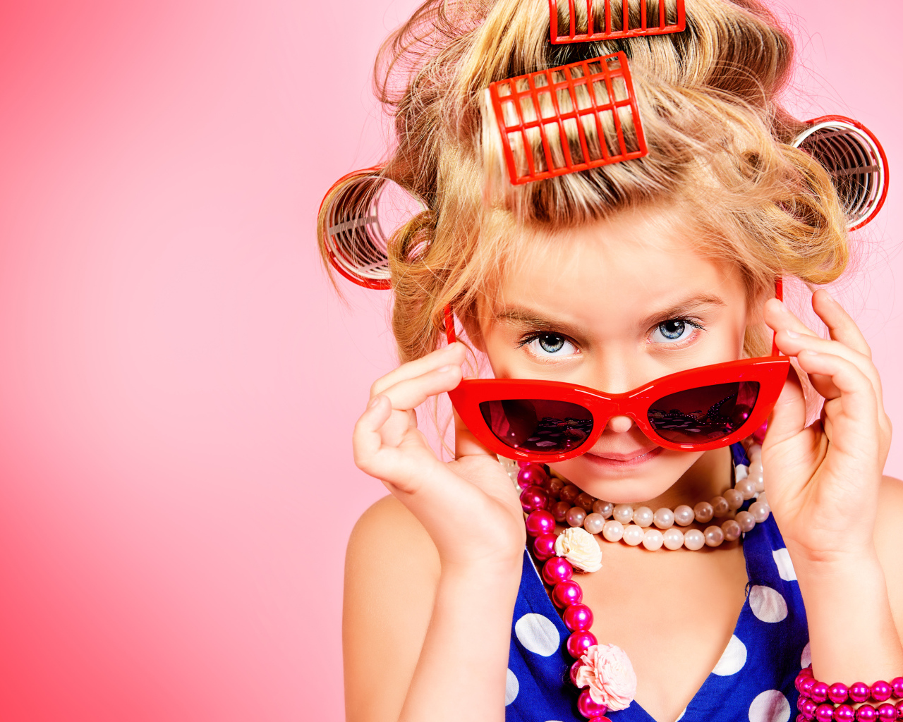 Гламурная девочка в больших красных очках и бигудями на голове