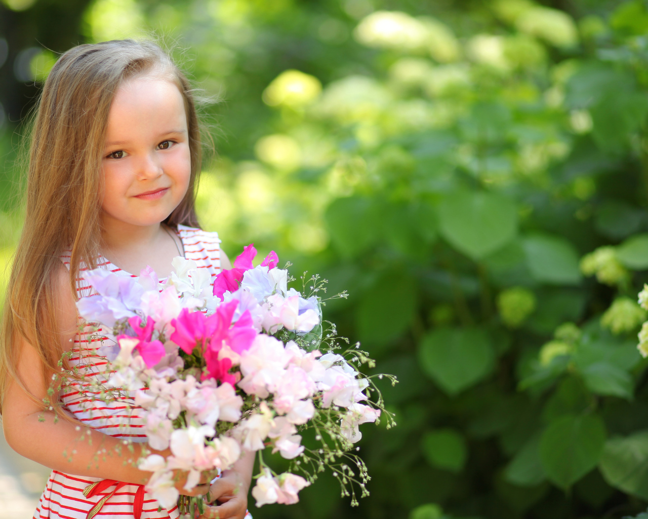 Русоволосая девочка с букетом цветов в руках
