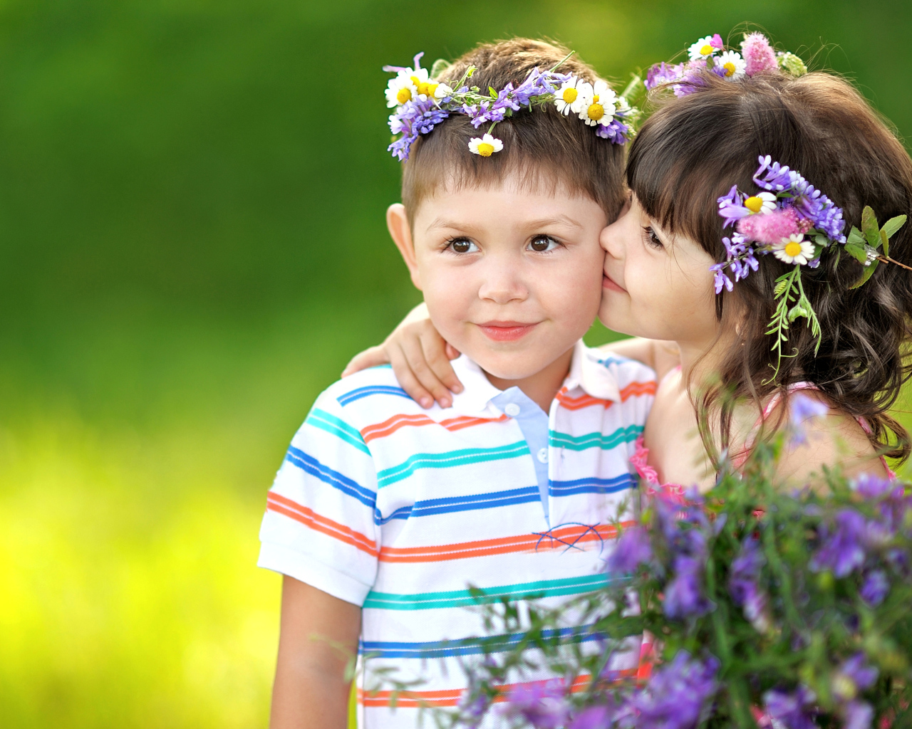 Маленькие мальчик и девочка с венками из полевых цветов на голове