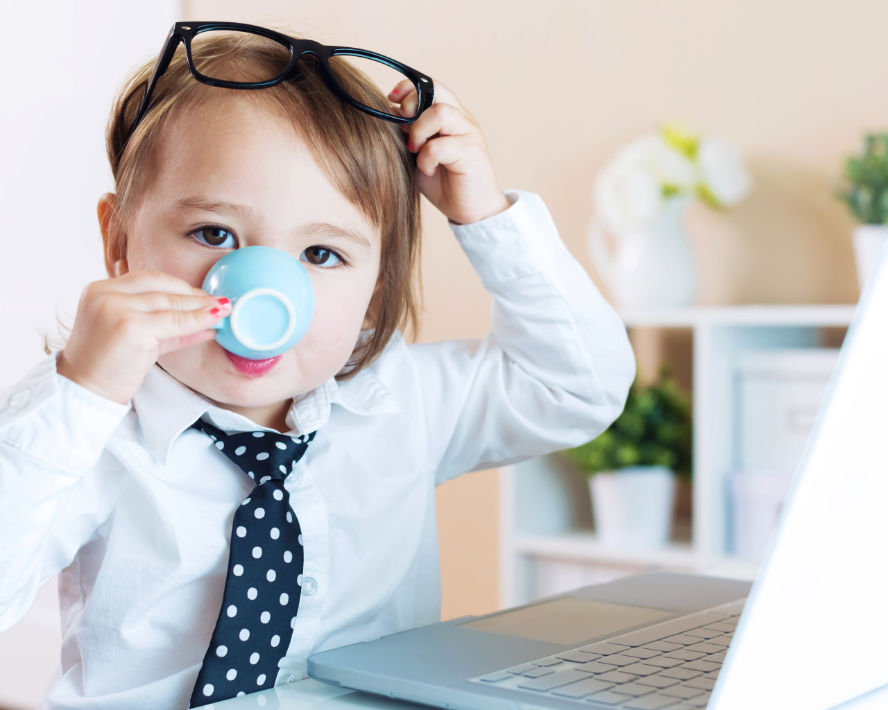 Маленький мальчик в деловом костюме и с чашкой