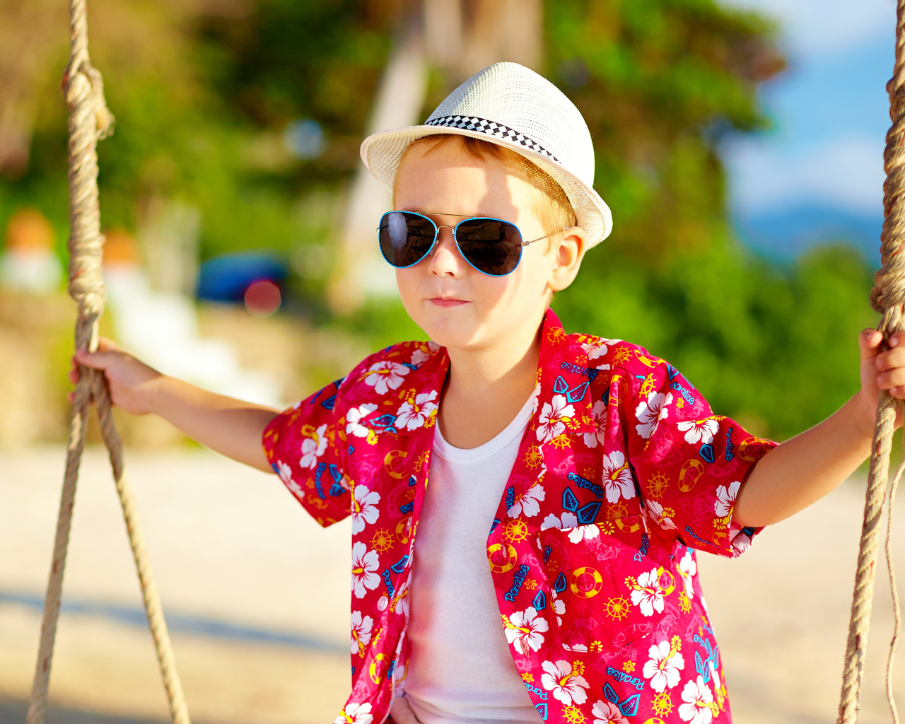 Маленький мальчик в белой шляпе и солнечных очках