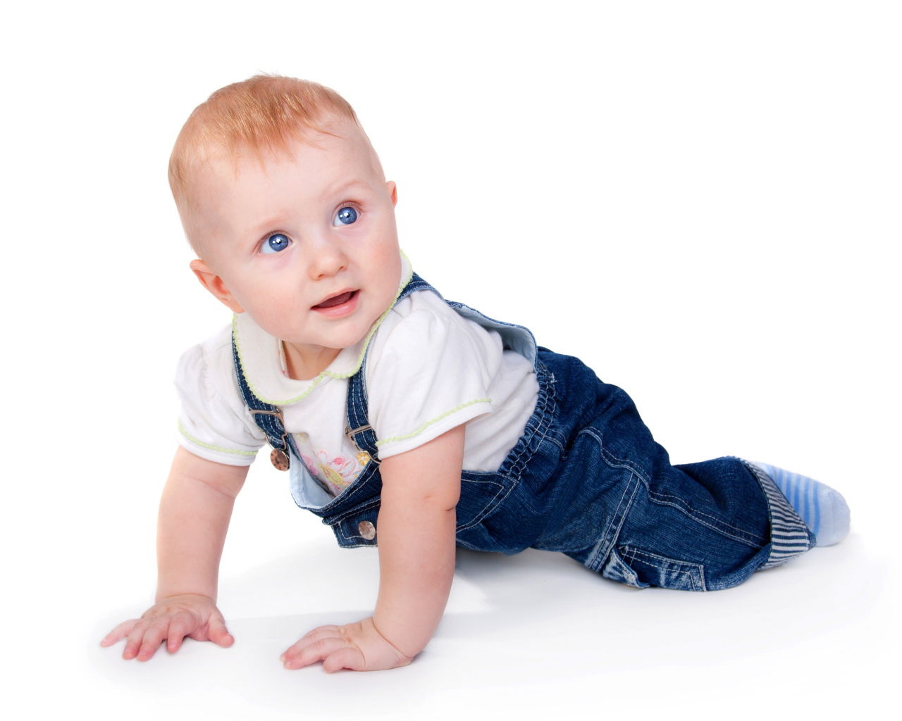 Маленький мальчик в синем комбинезоне на белом фоне