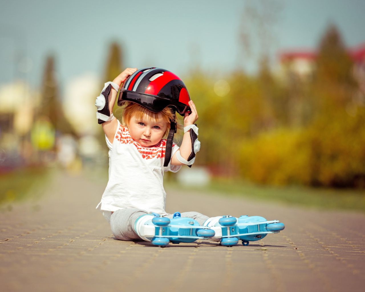 Маленький мальчик в шлеме и роликовых коньках