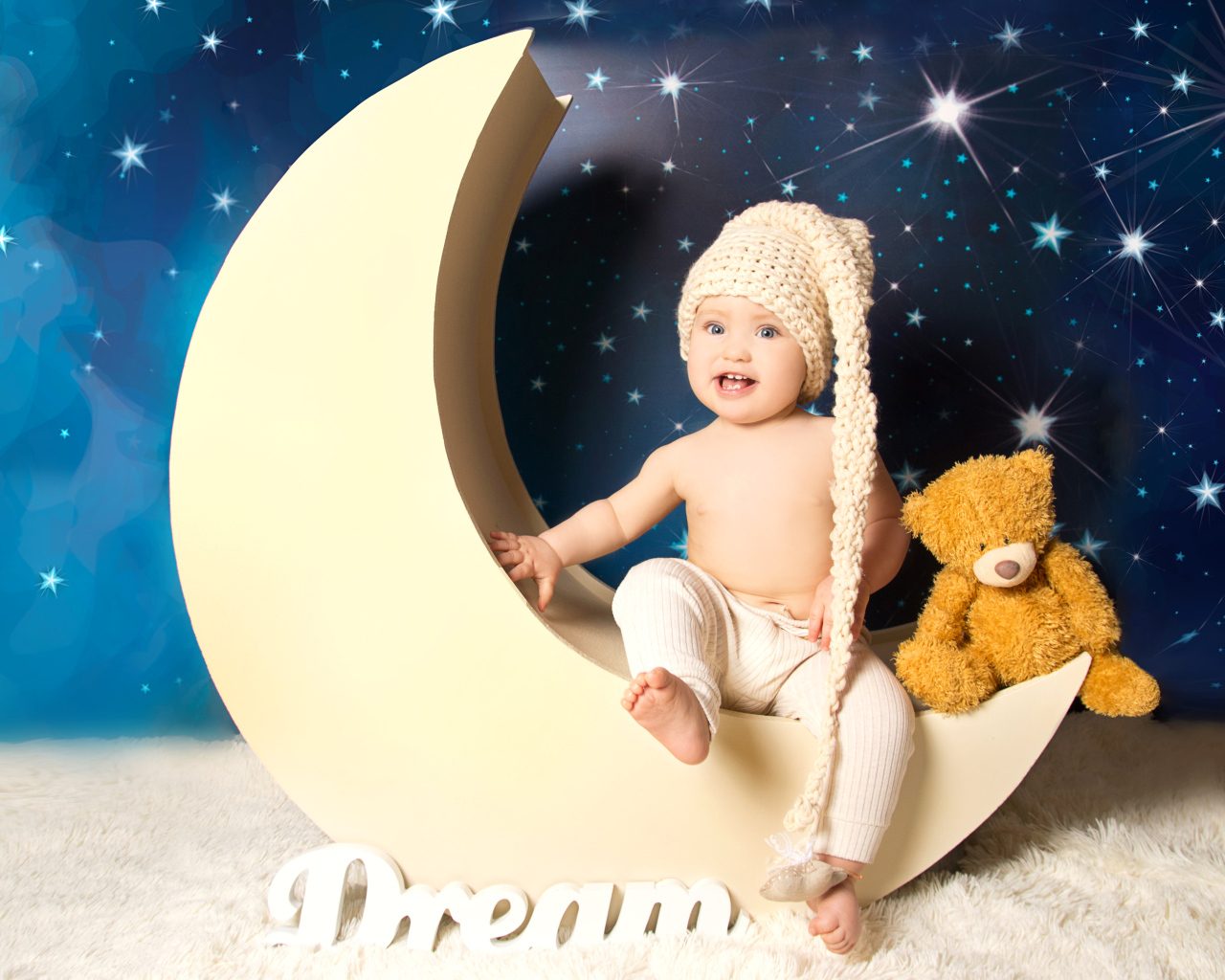 Маленький мальчик с плюшевым мишкой сидят на месяце