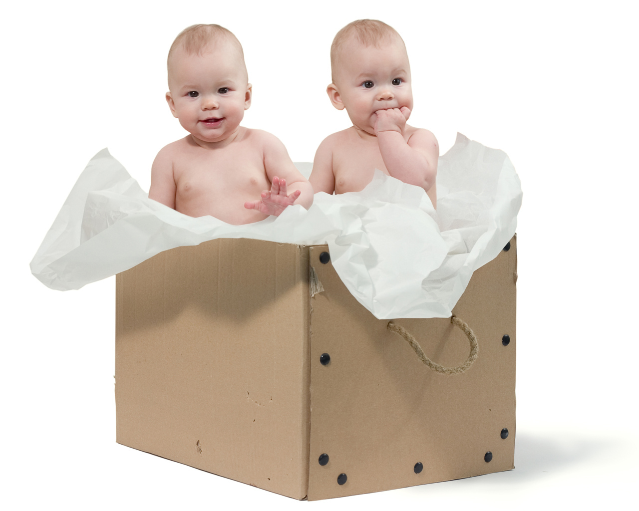 Маленькие дети сидят в картонной коробке с бумагой