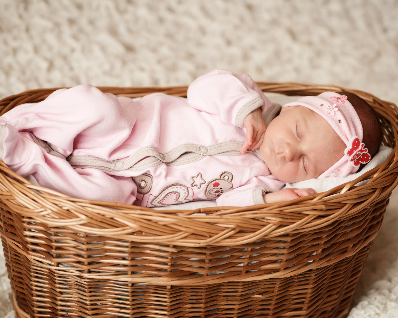 Маленькая милая девочка спит в большой корзине