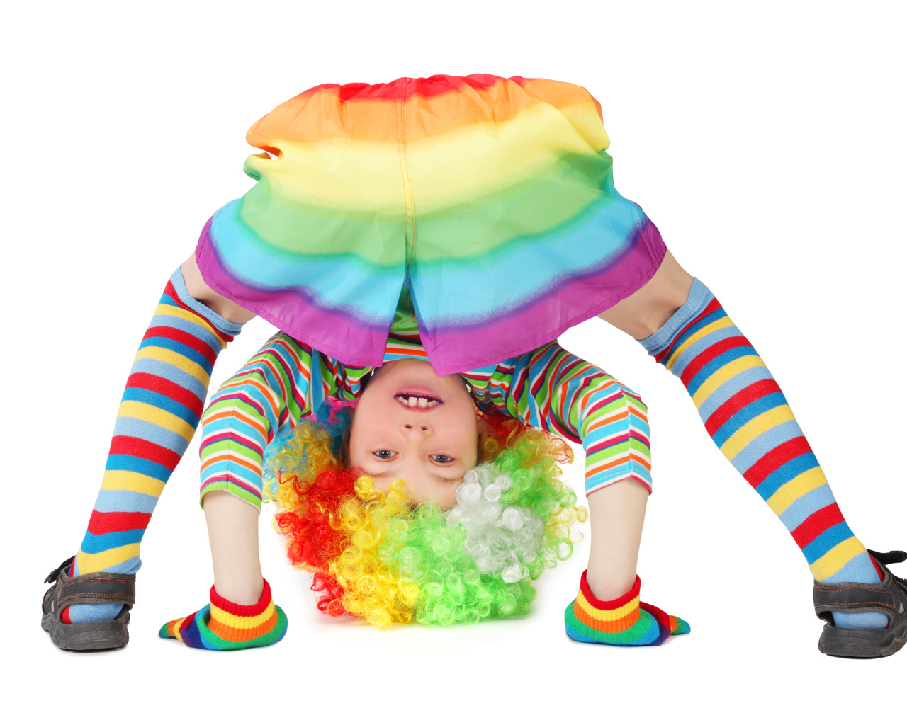 Маленькая смешная девочка в костюме клоуна на белом фоне