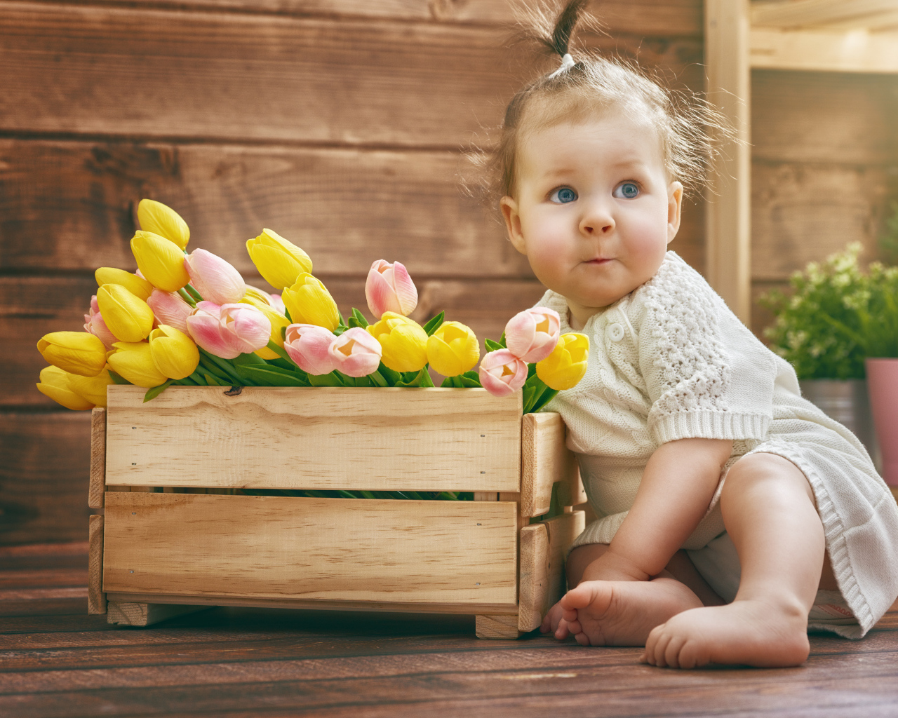 Маленькая забавная девочка с букетом тюльпанов