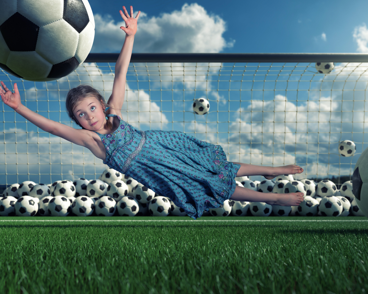 Маленькая девочка вратарь ловит мяч в воротах