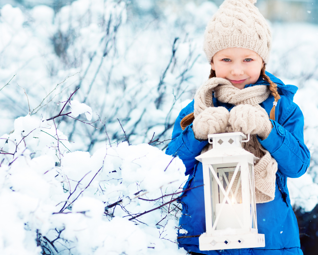 Маленькая девочка в синей куртке с фонарем  в руках зимой