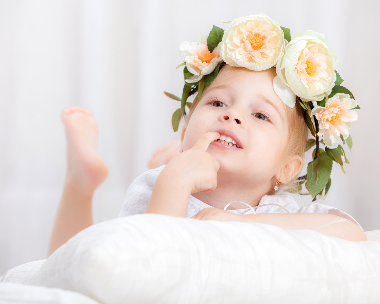 Маленькая девочка с красивым венком из цветов на голове