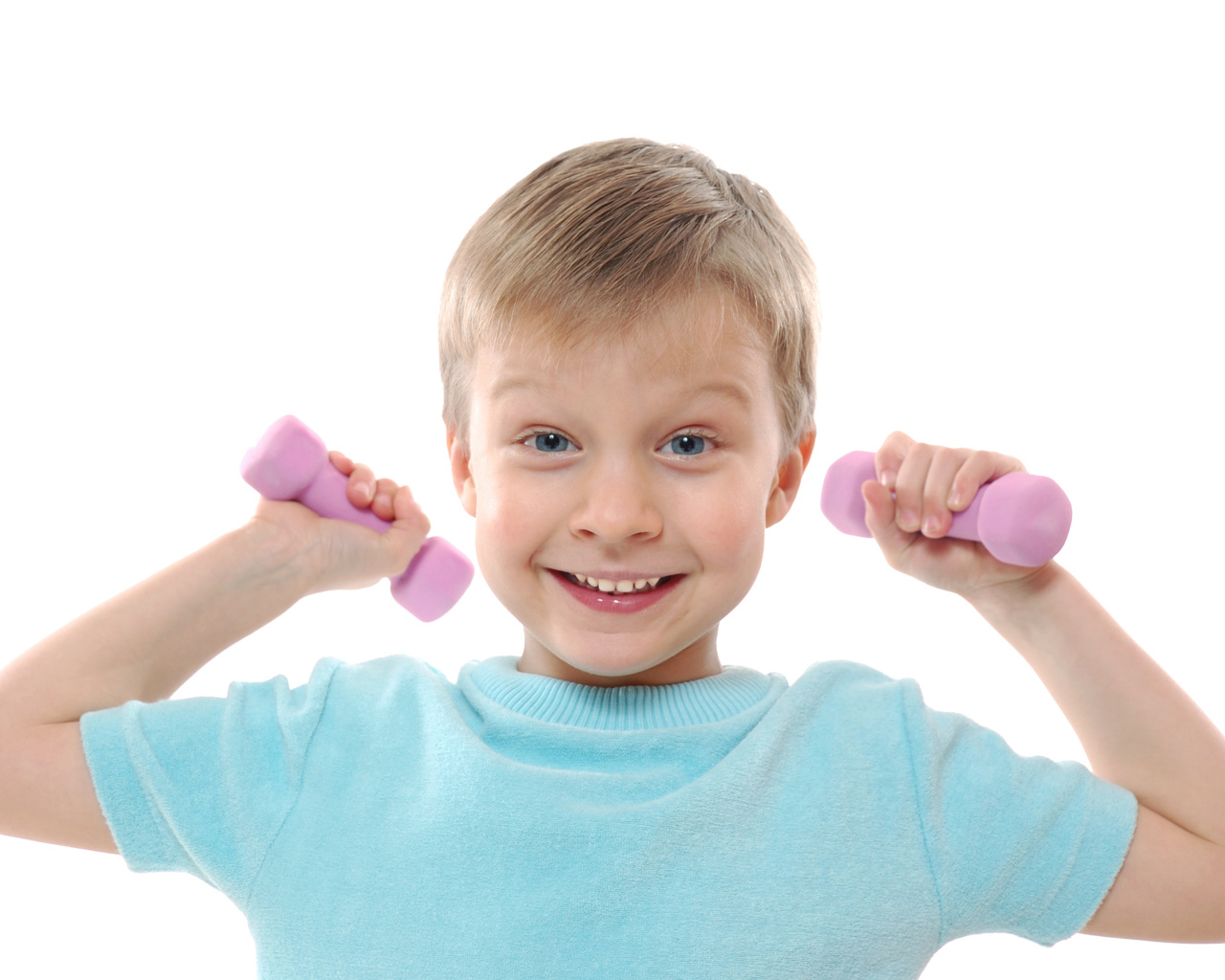 Маленький улыбающийся мальчик с гантелями на белом фоне