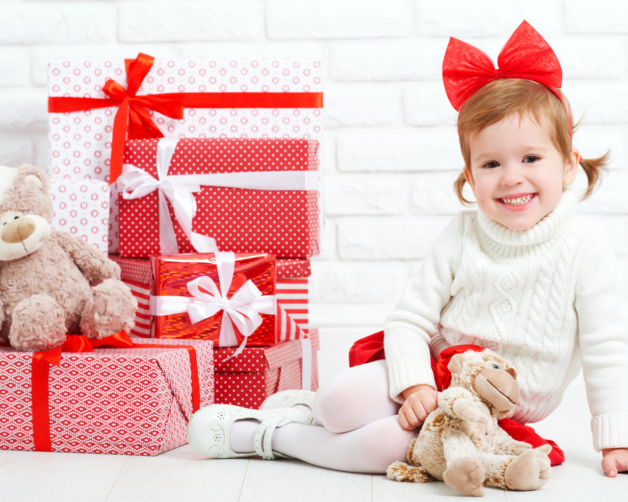 Маленькая улыбающаяся девочка с подарками на новый год