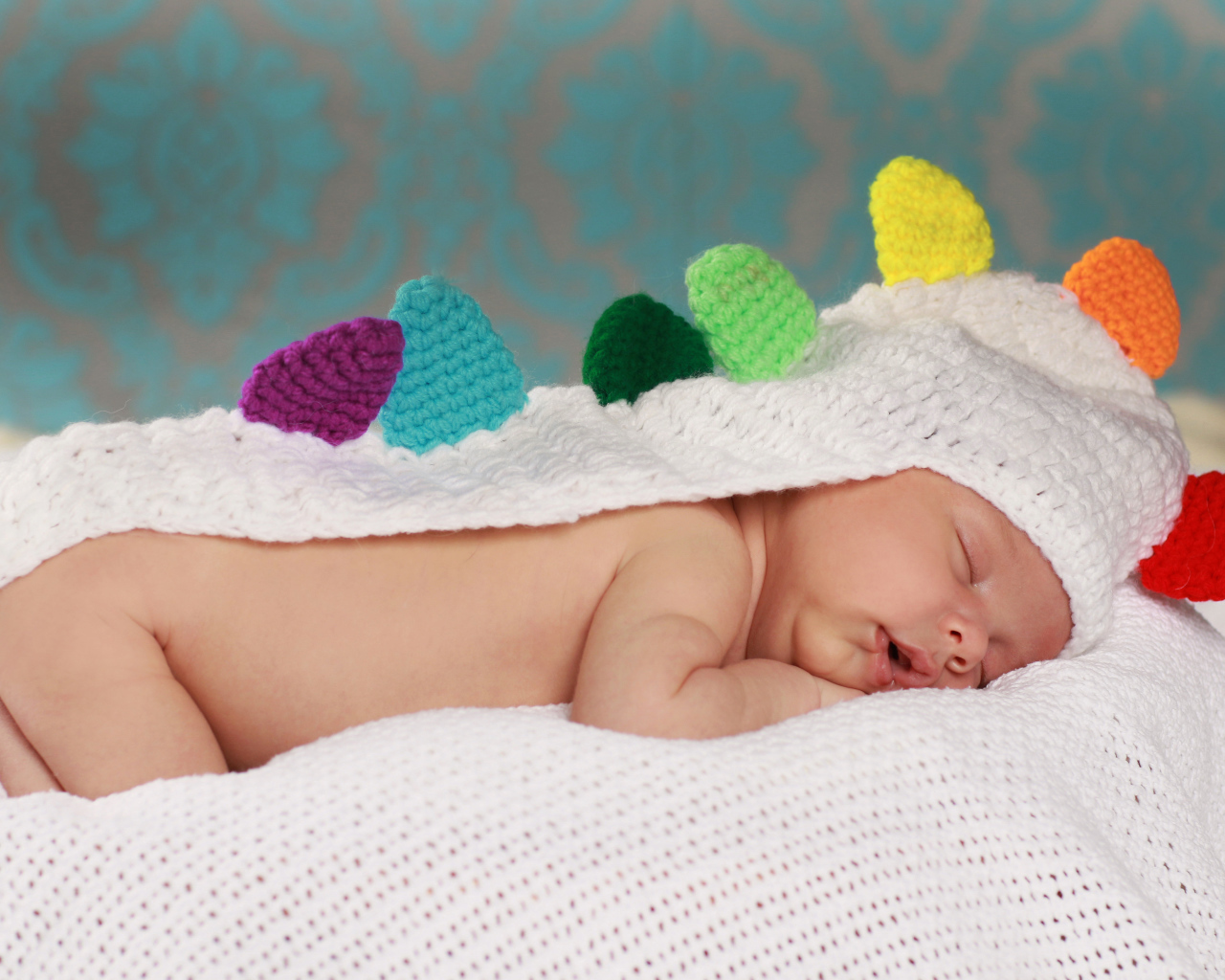 Спящий младенец в белой вязаной накидке