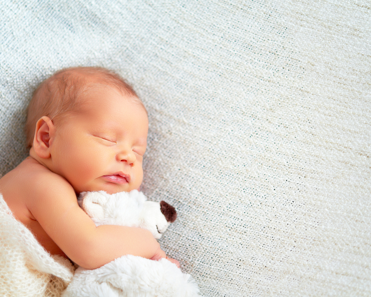 Спящий младенец с обнимает игрушку медведя