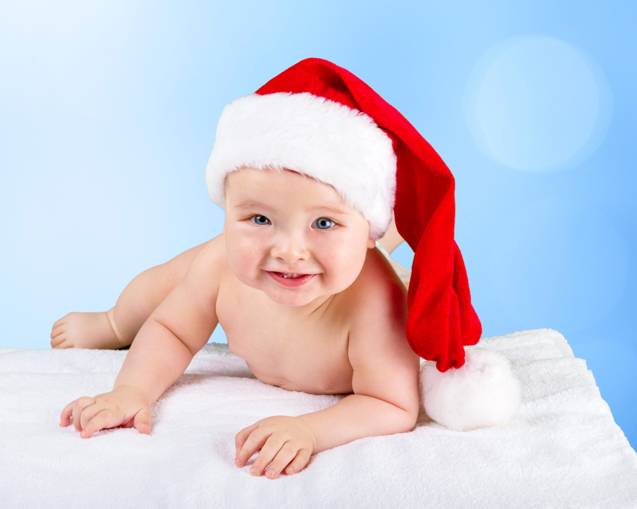 Улыбающийся грудной ребенок в новогодней шапке