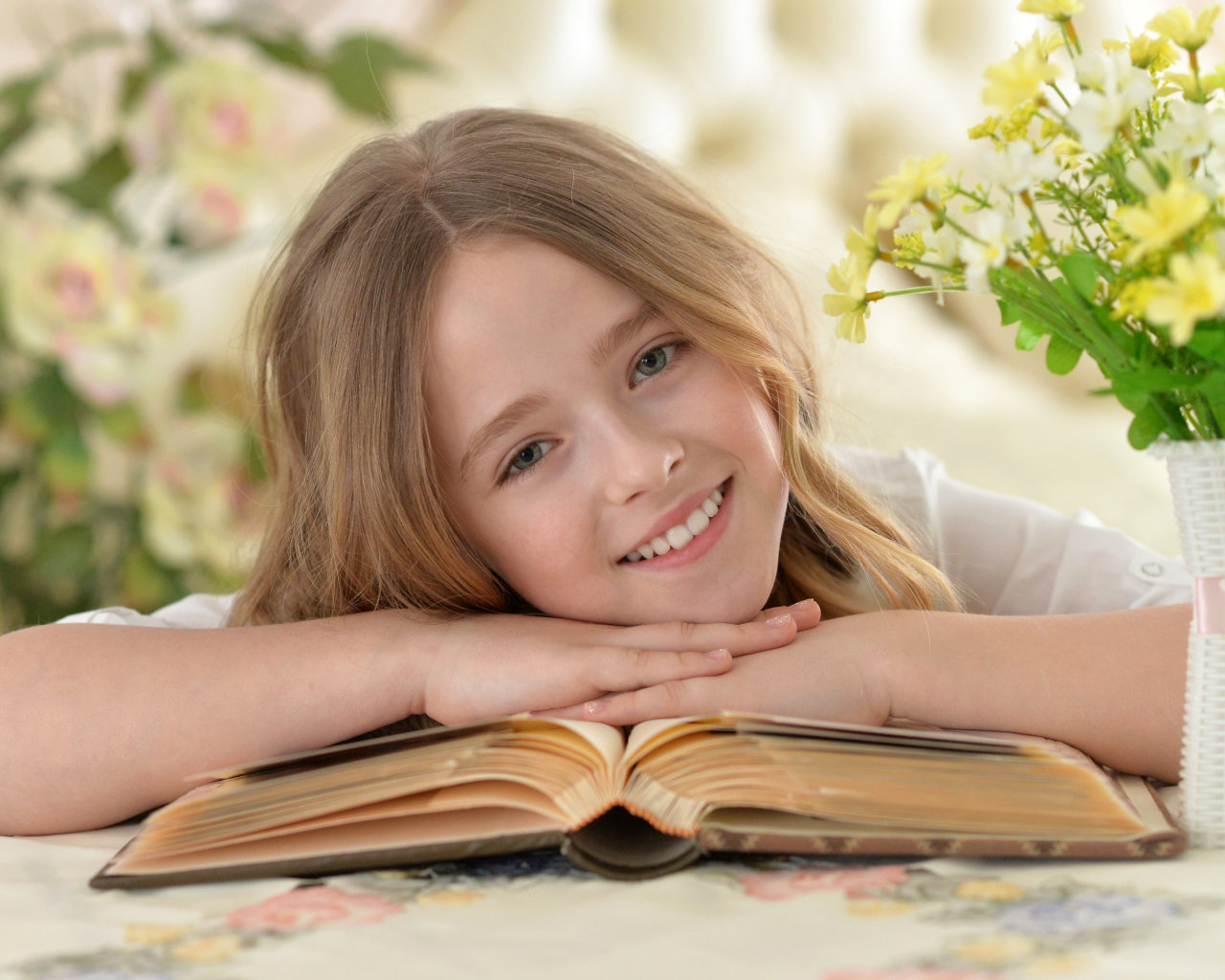 Улыбающаяся русоволосая девочка с книгой