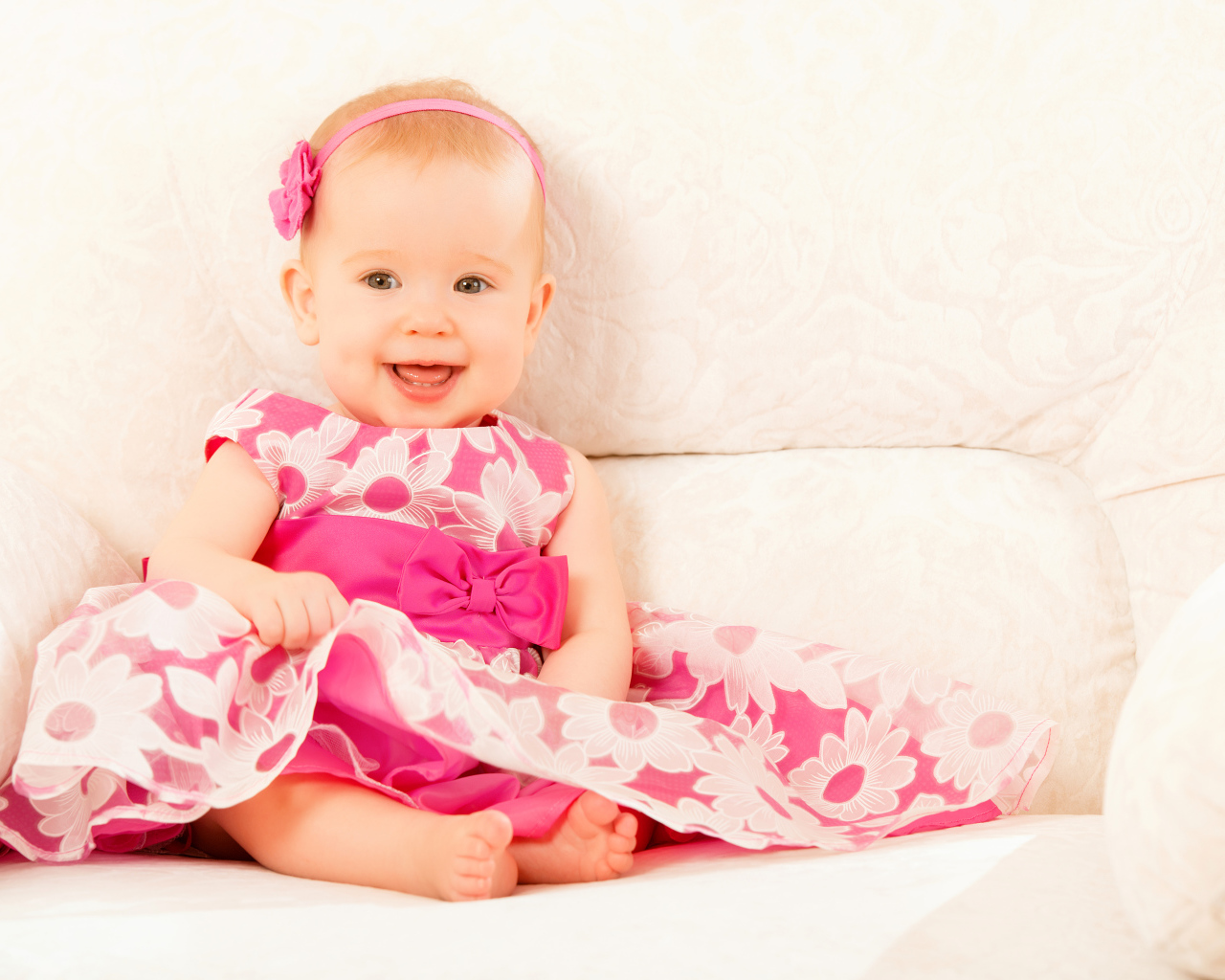 Улыбающаяся маленькая девочка в красивом розовом платье