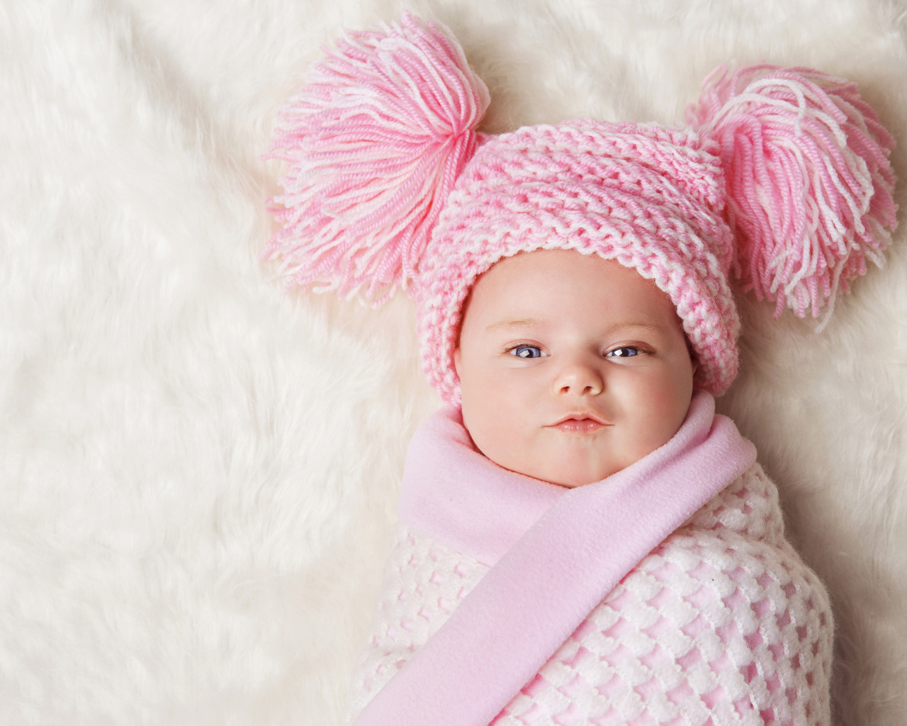Милая малышка в красивой розовой шапке 
