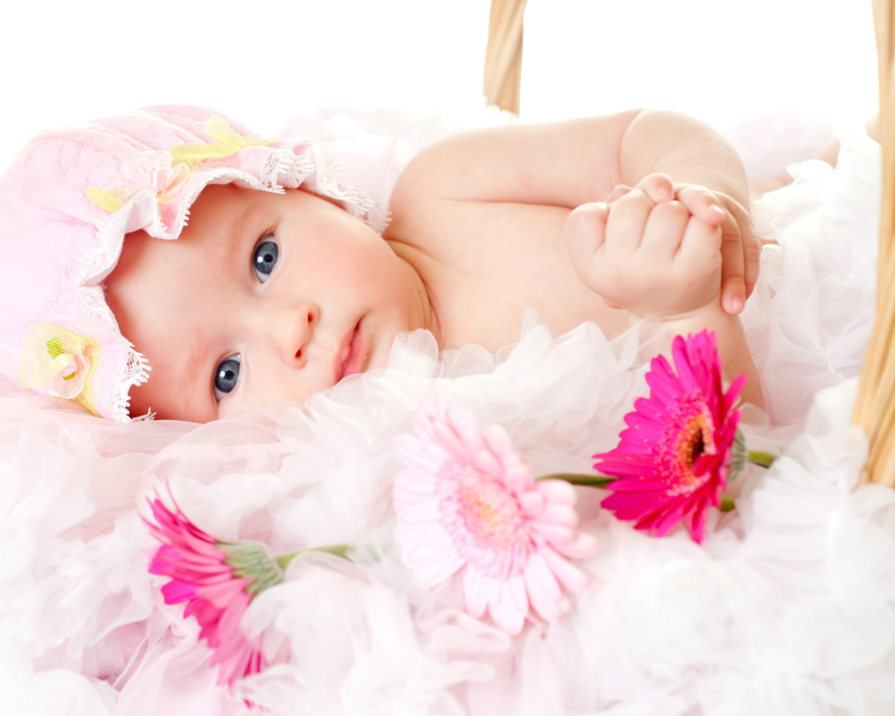 Милая девочка с шапке с тремя цветками герберы