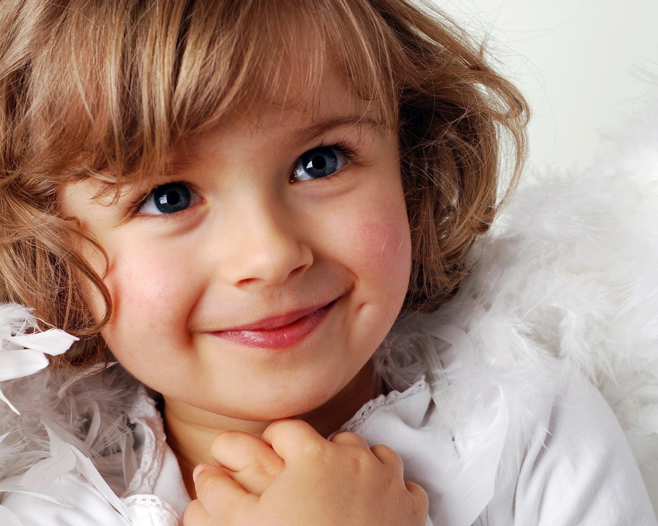 Маленькая голубоглазая девочка в костюме ангела 