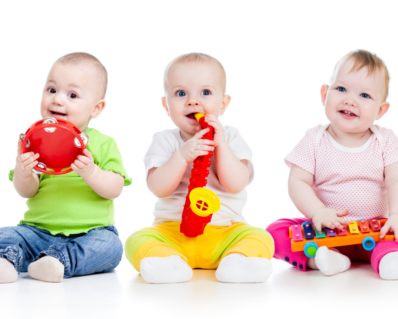 Три улыбающихся младенца играют на белом фоне