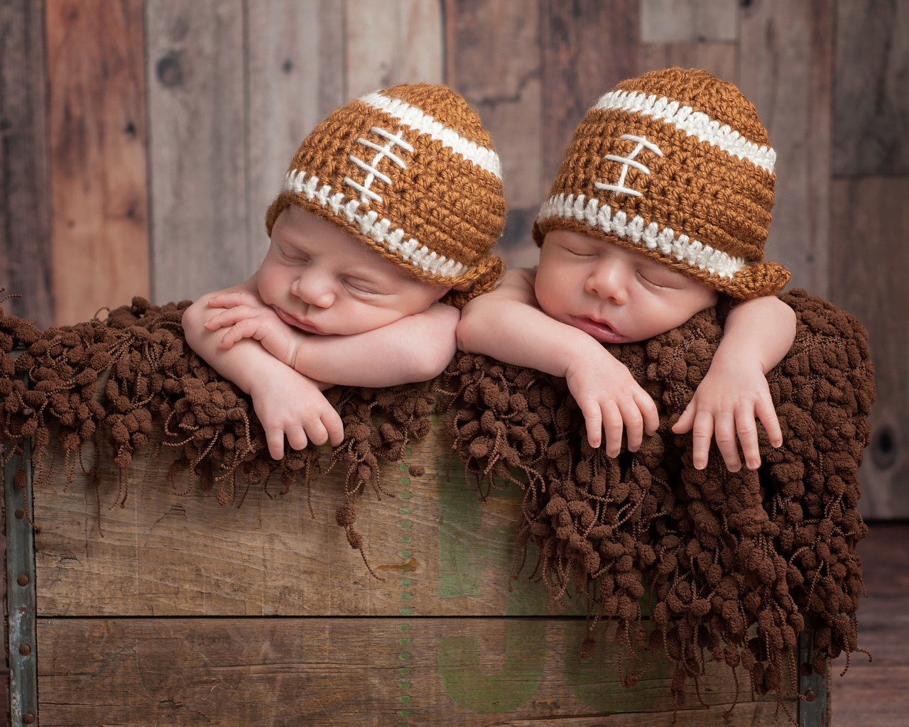 Два милых спящих малыша в забавных вязаных шапках