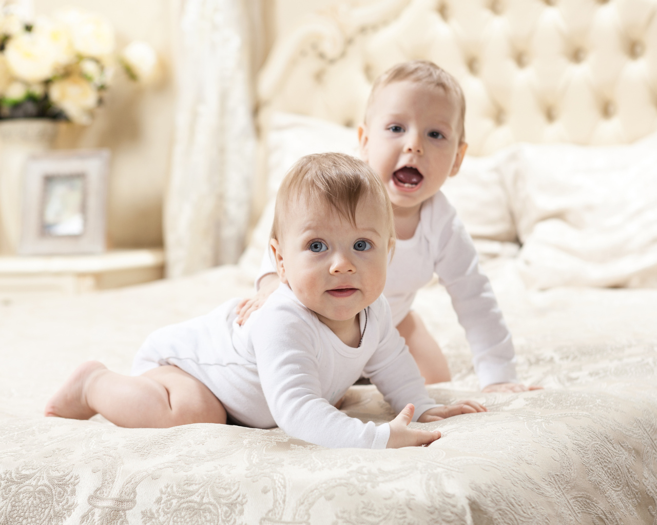 Два забавных младенца лежат на кровати