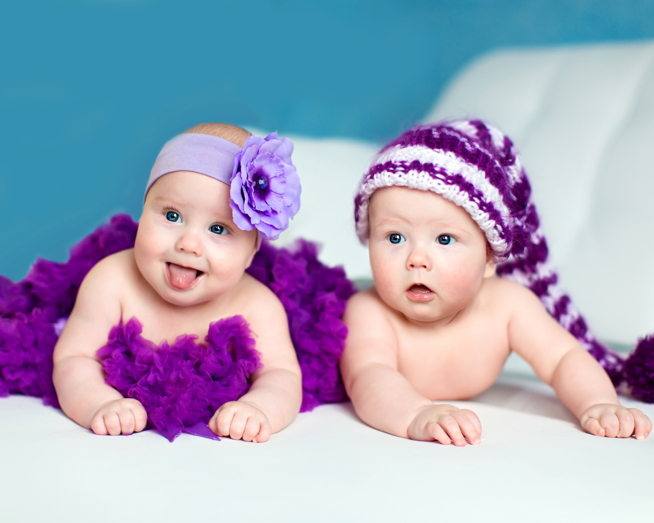 Два маленьких забавных младенца в красивых фиолетовых костюмах
