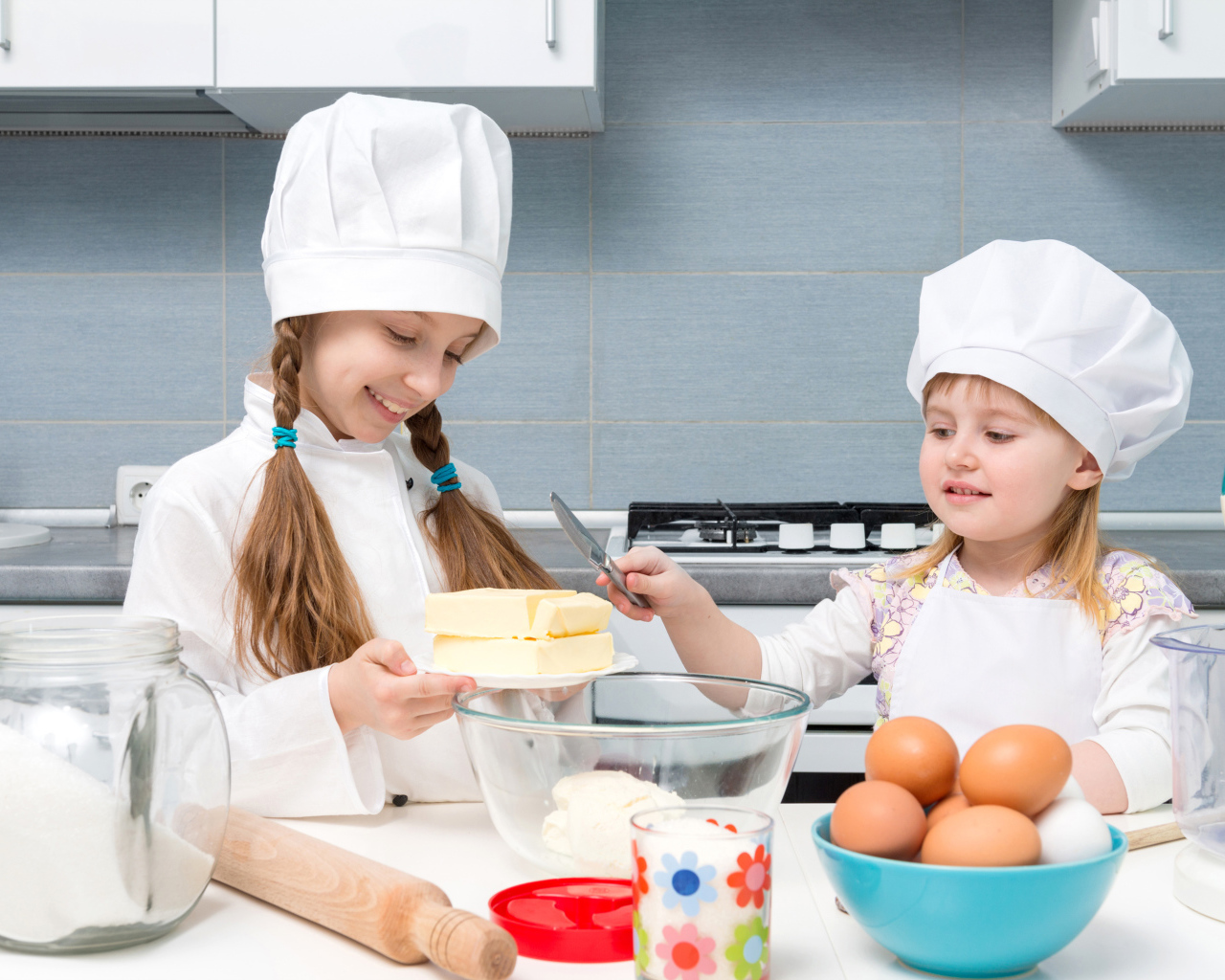 Две маленькие девочки на кухне готовят пирог