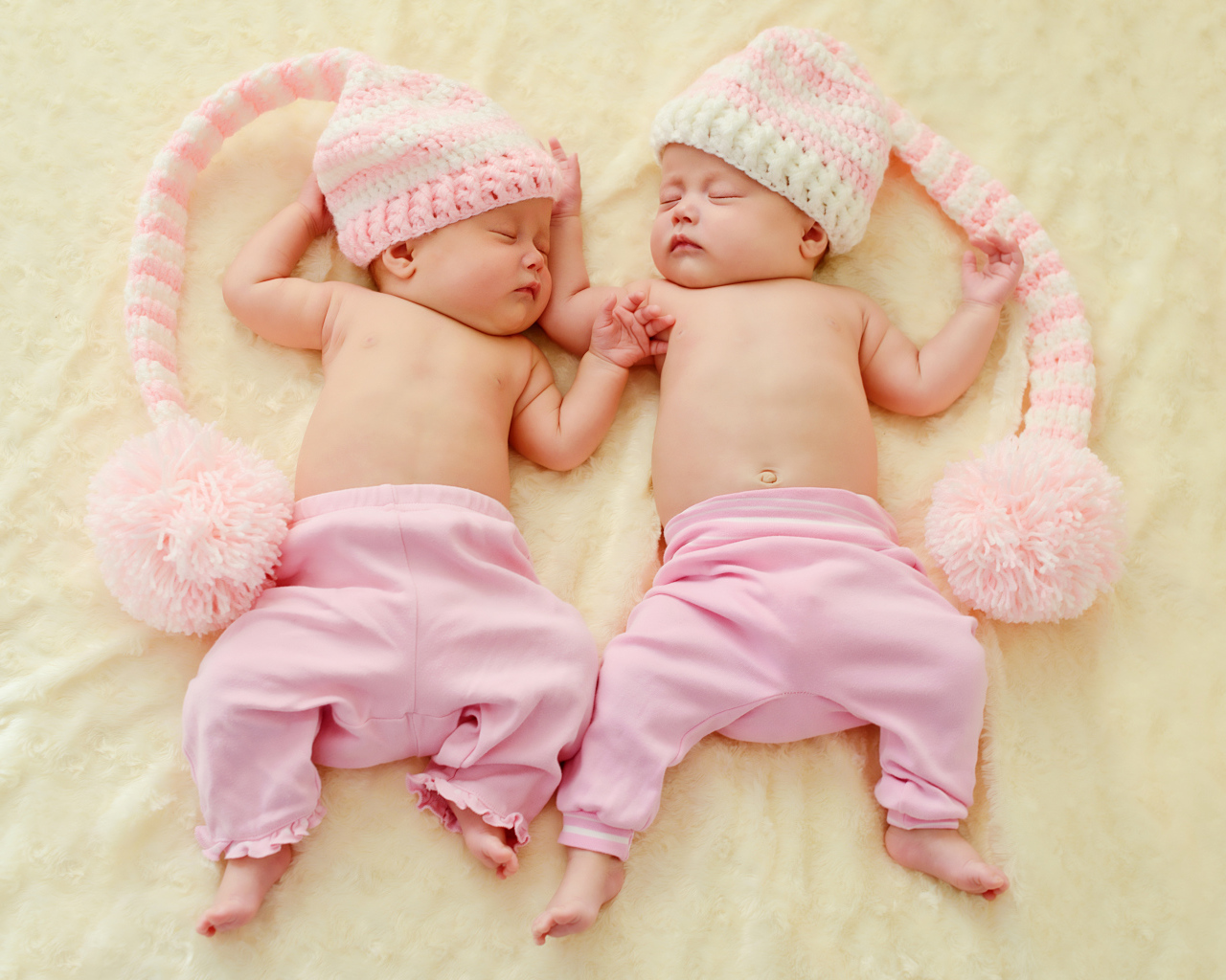 Два спящих грудных ребенка в розовых костюмах