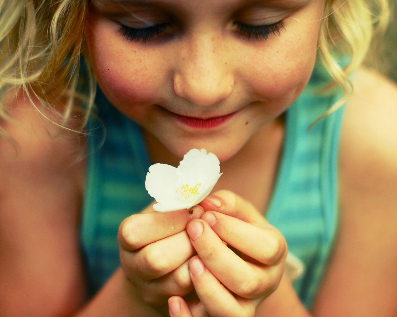 Маленькая девочка  держит белый цветок 