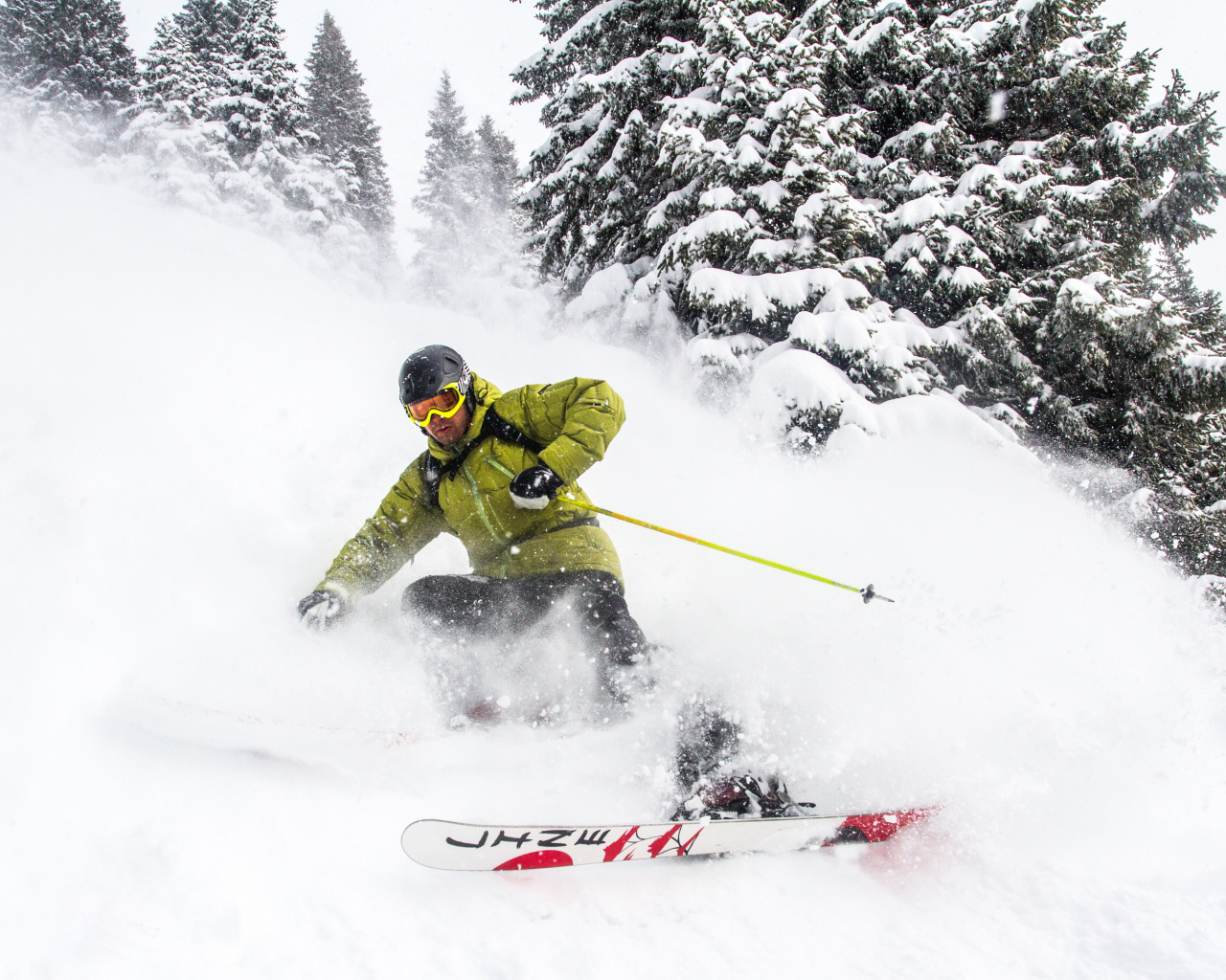 Спортсмен лыжник спускается по заснеженному склону