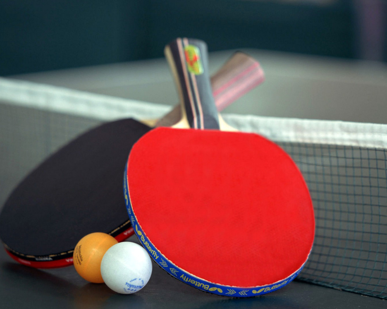 Ракетки для настольного тенниса и мячи на столе  