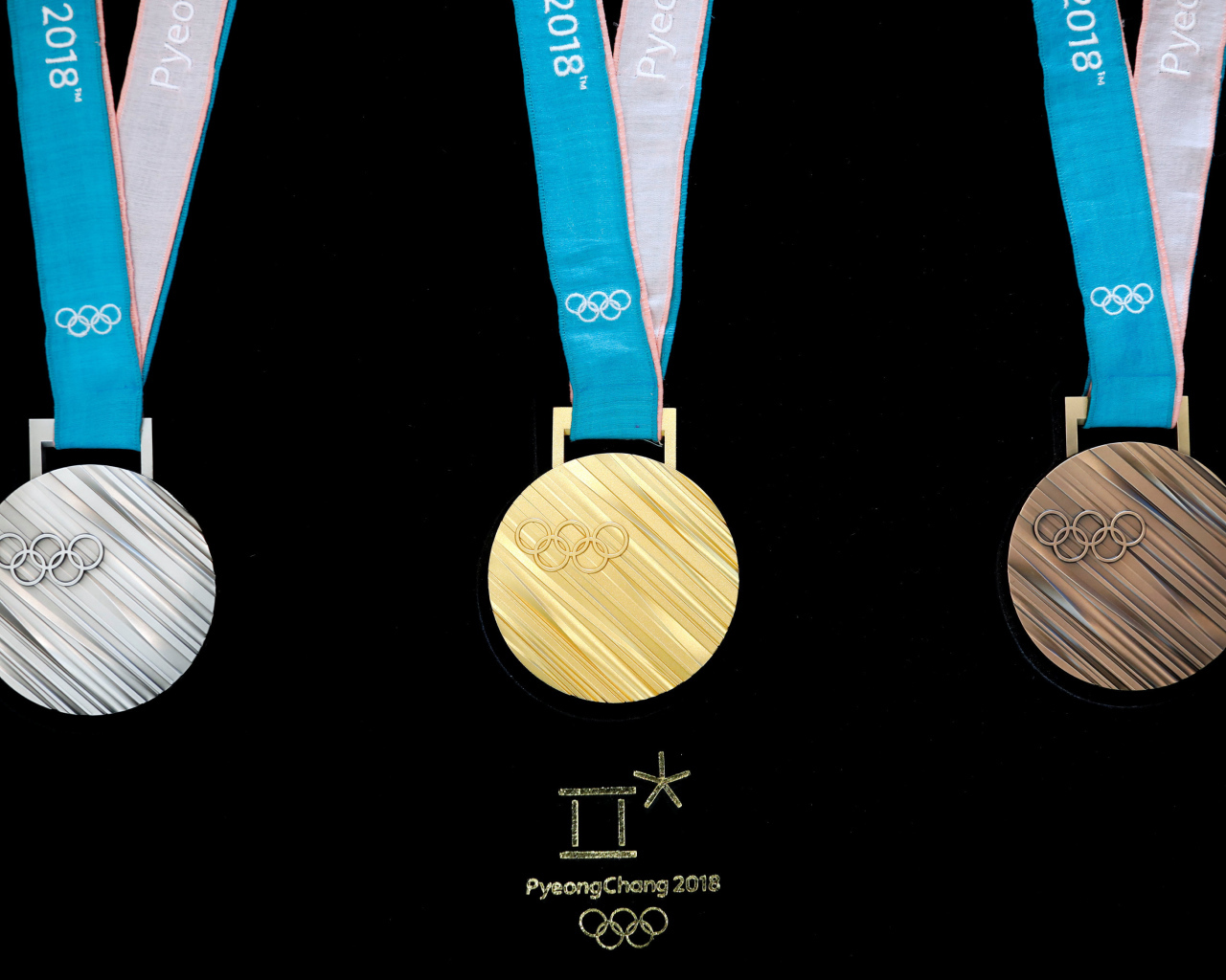 Три медали зимних Олимпийских игр 2018 на черном фоне