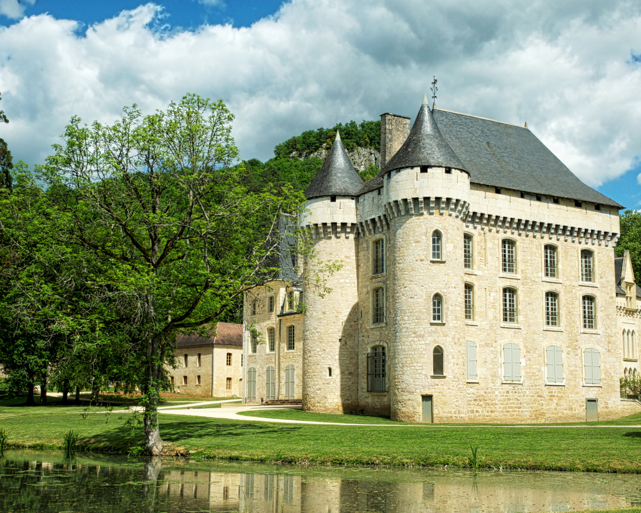 Старинный замок у пруда в зеленом саду, Франция