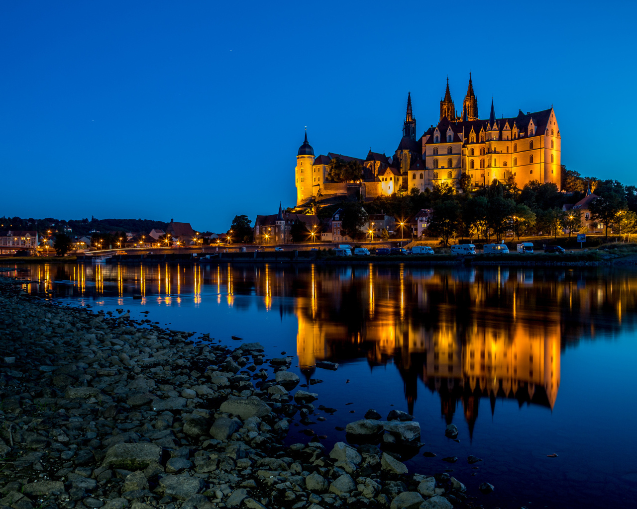 Evening lights of the castle of Albrechtsburg are reflected in the water, the city of Meissen, Germany