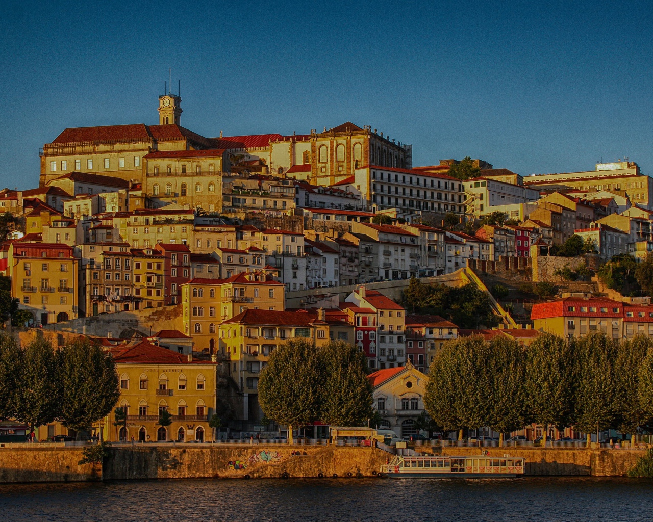 Панорама города Коимбра у воды на закате солнца,  Португалия
