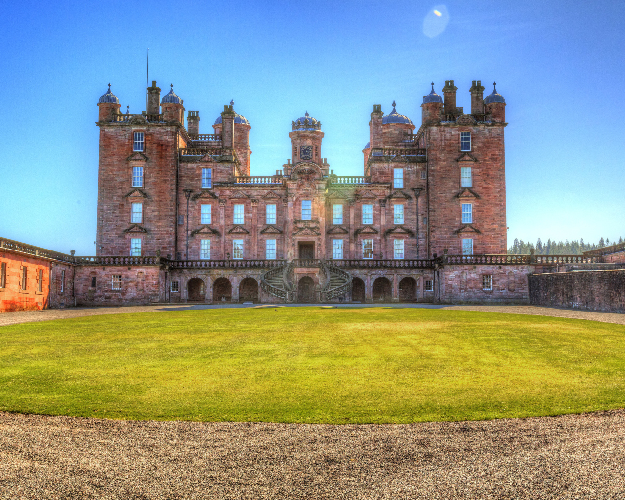 Замок Drumlanrig Castle с зеленым  газоном, Шотландия 