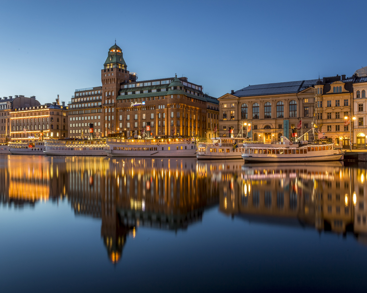 Beautiful houses are reflected in the water at the pier in the evening, Stockholm. Sweden