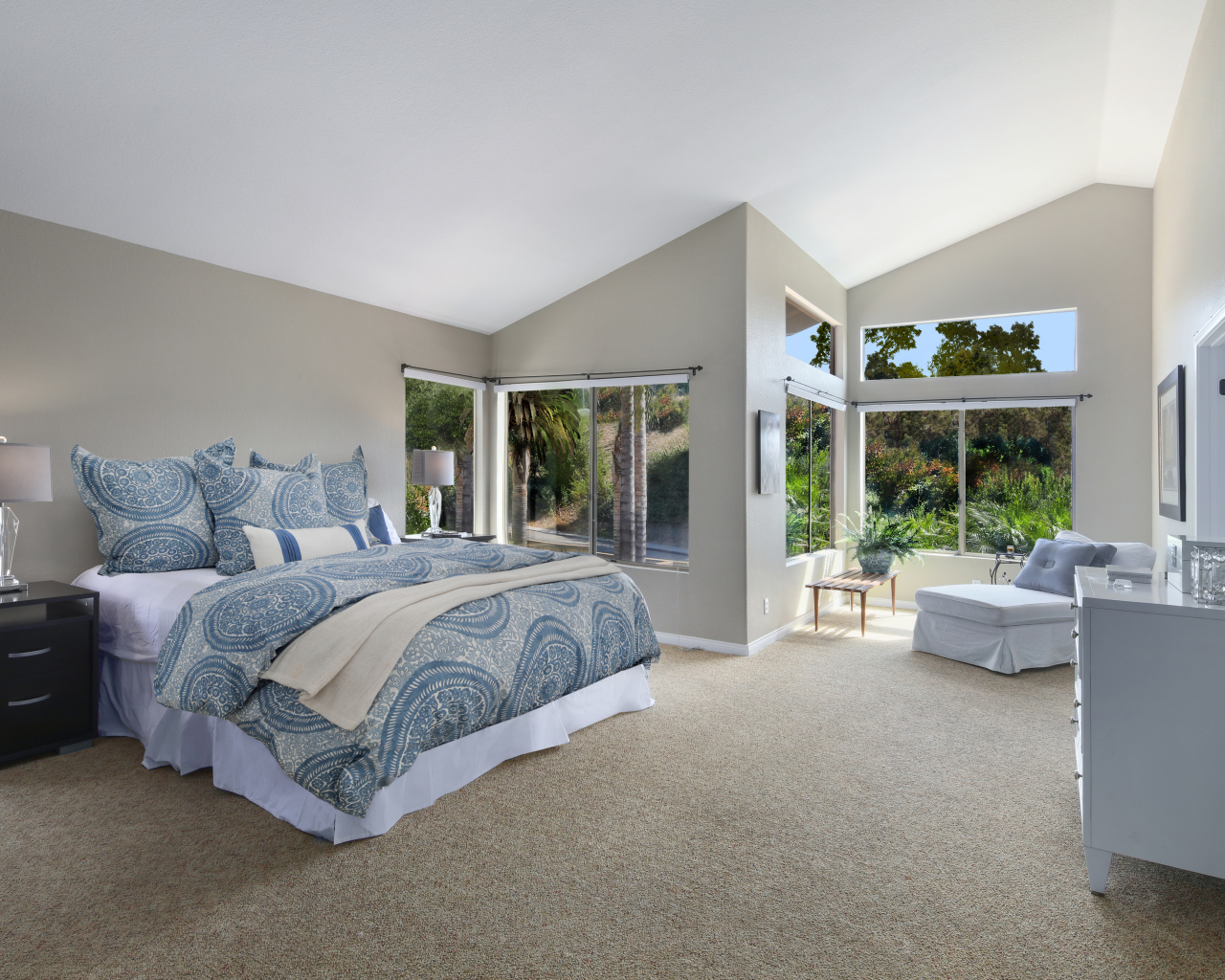 Уютная спальная комната в серых тонах с большими окнами