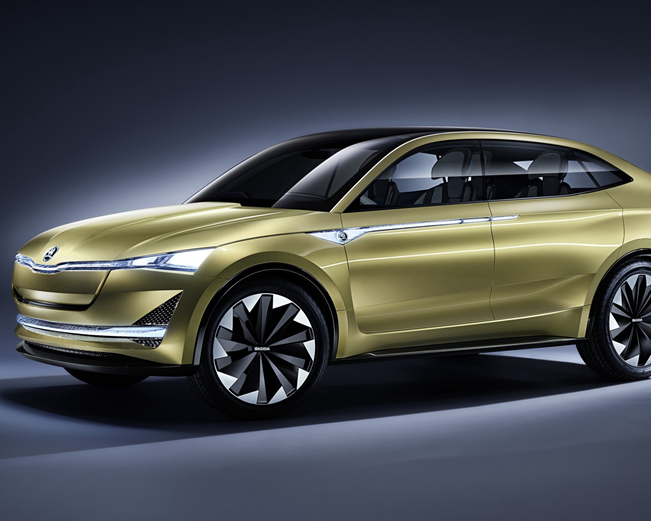 Электромобиль Skoda Vision E цвета золотой металлик на сером фоне