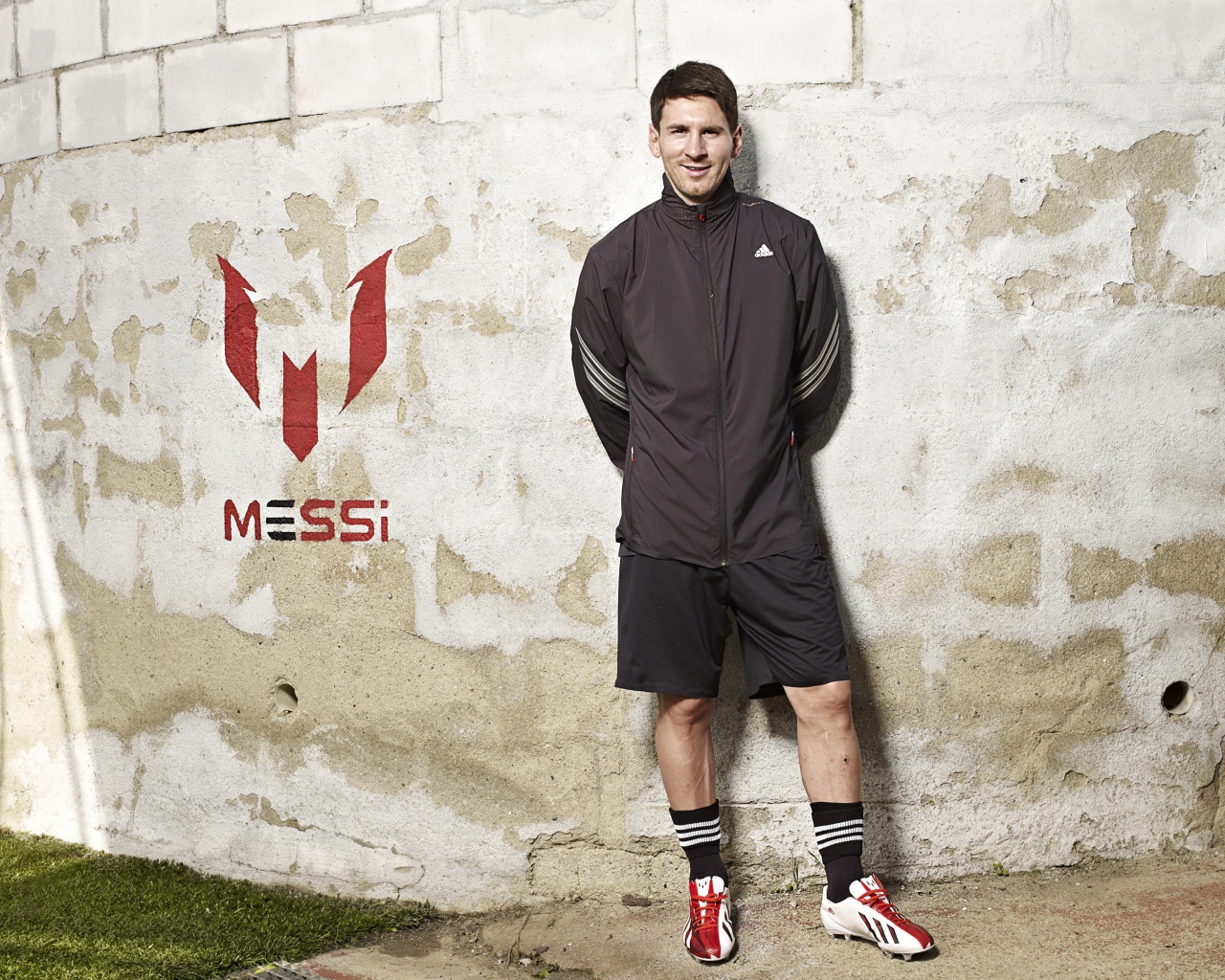 Футболист Лионель Месси позирует  на фоне стены 