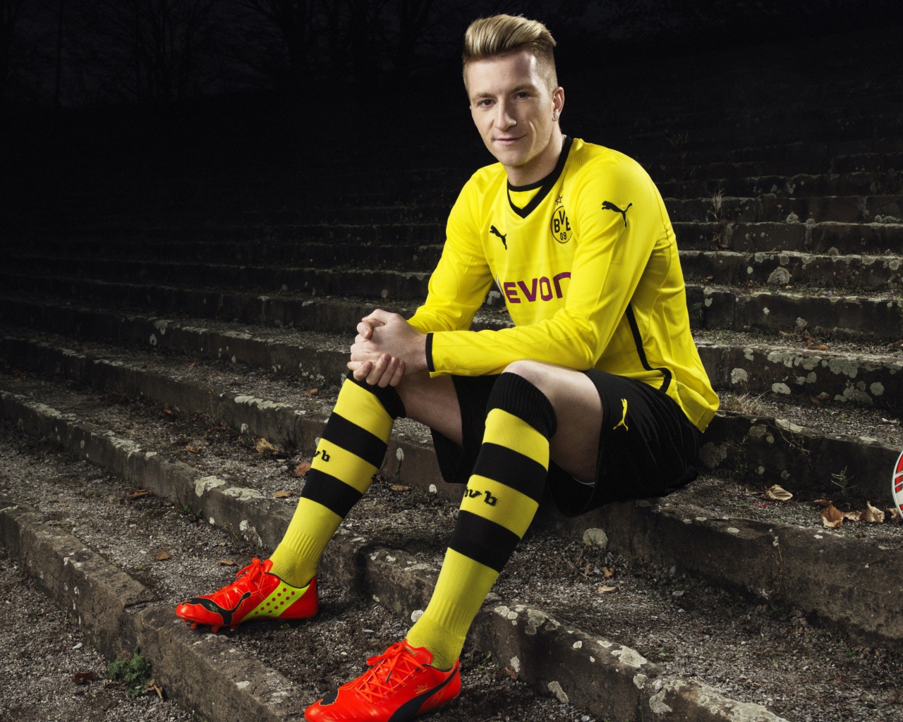 Немецкий футболист Марко Ройс сидит на ступеньках 