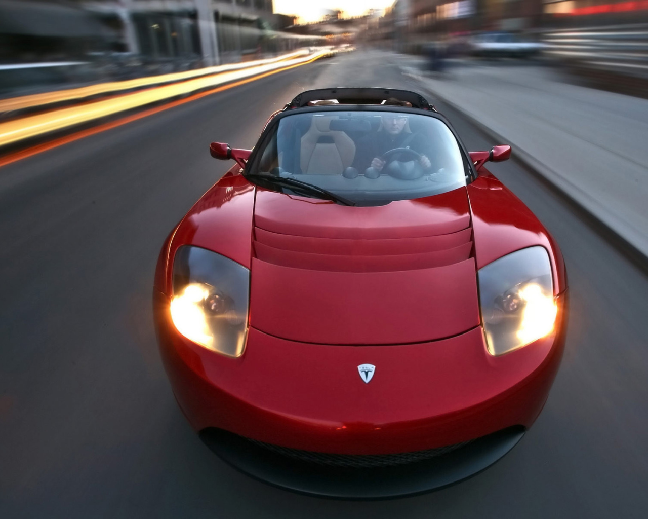 Красный электромобиль Tesla Roadster на трассе 