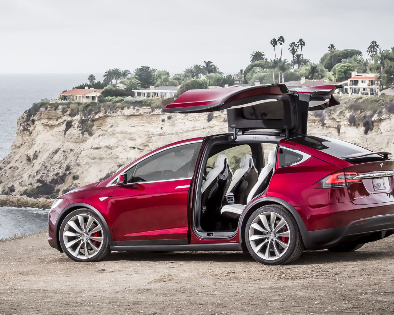 Красный электромобиль Тесла на берегу 