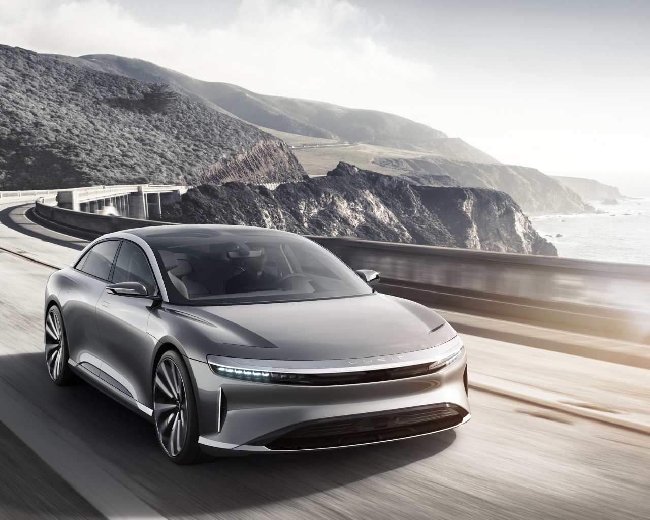 Серебристый электрокар Lucid Air  на трассе